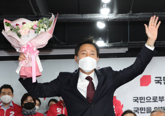 4·7 재보궐 선거에서 서울시장 당선이 확실해진 국민의힘 오세훈 후보가 8일 서울 여의도 당사 개표상황실에서 꽃다발을 받고 기뻐하고 있다. 연합뉴스.
